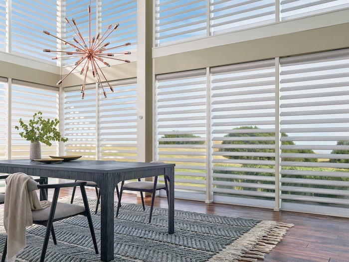 A dining room with a modern dining table and a vintage starburst lamp.